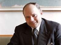 Theodor Blank schaut lächelnd für eine Portraitaufnahme in die Kamera.