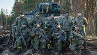 Neun Soldaten der Bundeswehr posieren vor einem Schützenpanzer Puma für ein Gruppenbild.