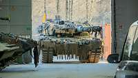 Ein Schützenpanzer Leopard fährt in eine Instandsetzungshalle auf den Betrachter zu.