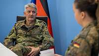 Ein Soldat und eine Soldatin sitzen sich gegenüber und führen ein Gespräch