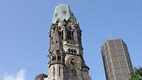 Die Ruine der zerbombten historischen Kirche und der markante Neubau der Gedächniskirche in Berlin