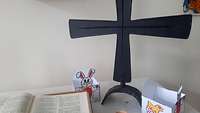 Eine Bibel, ein Kreuz, ein Eierbecher und zwei österlich gestaltete kleine Schachteln auf dem Tisch