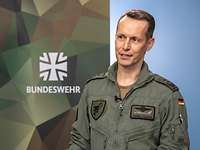 Zwei Soldaten stehen sich an einem Tisch gegenüber und sprechen miteinander