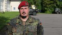 Ein Soldat mit rotem Barett und Bart schaut ernst in die Kamera.