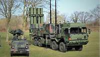 Zwei Militärfahrzeuge stehen auf einer Wiese.