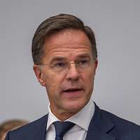 Mark Rutte sitzt an einem Konferenztisch und spricht
