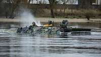 Ein Transportpanzer vom Typ Fuchs schwimmt in einem Gewässer