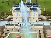 Ein Schloss mit einem Springbrunnen im Vordergrund