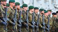 Soldaten stehen mit ihren Gewehren angetreten beim Appell