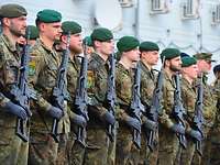 Soldaten stehen mit ihren Gewehren angetreten beim Appell