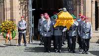 Soldaten tragen einen Sarg aus dem Dom