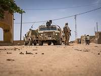 Einsätze und Missionen (2/7) Ein bewaffneter Soldat steht neben Militärfahrzeugen während einer Patrouille in Mali