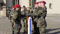 Soldaten haben ihre Hände auf eine Flagge gelegt und halten ein Gelöbnis ab