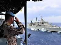 Zum Gruße Ein Soldat steht auf einem Schiff und grüßt ein vorbei fahrendes Schiff.