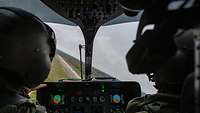 Zwei Piloten sitzen im Cockpit eines Hubschraubers.