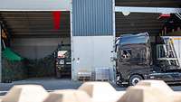 Militärische Lkw parken in Hallen.