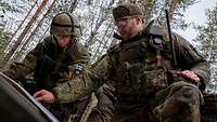Ein finnischer und ein deutscher Soldat schauen auf eine Karte.