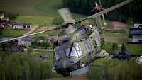 Ein Hubschrauber vom Typ NH-90 fliegt über eine Ortschaft