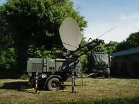 Gelber Merkur 2025 - SatCom-Anlage Eine Anlage für Satellitenkommunikation steht auf einer Wiese vor einem getarnten LKW