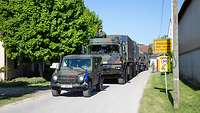 Eine militärische Fahrzeugkolonne bei einer Ortsdurchfahrt