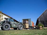 Ein Feldumschlaggerät belädt einen Container auf einem LKw