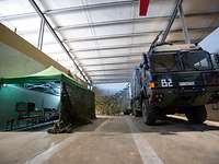 Ein LKw steht in einer Halle mit Tarnnetzen und einem Zelt