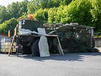 Ein Bundeswehrfahrzeug unter einem Tarnnetz und Gerümpel