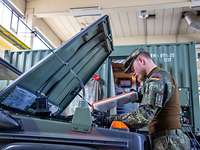 Ein Soldat blick in einen Motorraum eines Bundeswehrfahrzeuges