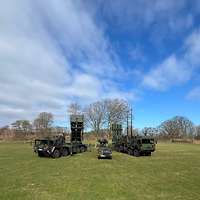 Drei Fahrzeuge stehen auf einer Wiese.