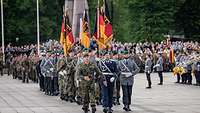 Sehr viele Soldaten marschieren auf einem öffentlichen Platz.