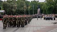 Soldatinnen und Soldaten marschieren in Formation über den Appellplatz.