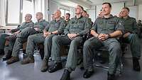Soldaten in Overalls sitzen in einem Raum 