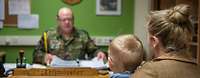 Familienbetreuung Mutter mit ihrem Sohn auf dem Schoß sitzt einem Soldaten gegenüber