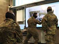 Technikunterricht am GTK Boxer Ausbilder erläutert Technik am Monitor, mehrere ukrainische Soldaten hören zu
