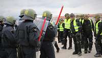 Realistisches Szenario Demonstranten in grellgelben Warnwesten stehen Soldaten mit Helm und Schild gegenüber.