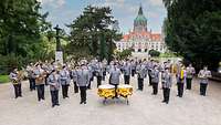 Saldaten stehen mit Instrumenten vor einem imposantem Gebäude