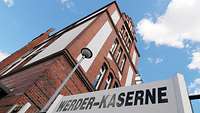 A sign for the Werder Barracks in front of a building