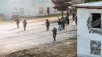 Soldaten führen feindliche Paramilitärs ab.