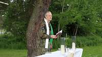 Ein Militärpfarrer steht hinter einem Altar beim Feldgottesdienst