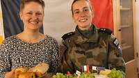 Zwei Frauen präsentieren typisch französische Frühstücksspeisen.