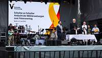 Drei Militärgeistliche stehen auf der Bühne und halten einen Gottesdienst ab
