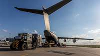 Ein Transportflugzeug wird von hinten beladen.