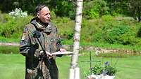 Ein Soldat steht am Mikrofon und liest etwas