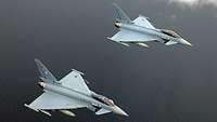 Zwei Kampfjets fliegen über Wasser.