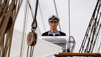 Ein Soldat in Marineuniform auf einem Segelschiff.
