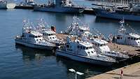 Kieler Woche 2025 Mit Flaggenketten geschmückte Patrouillenboote und Kriegsschiffe liegen am Kai eines Militärhafens