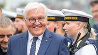 Empfang auf der Gorch Fock Frank-Walter Steinmeier lächelt in die Kamera, im Hintergrund stehen Soldatinnen und Soldaten der Marine