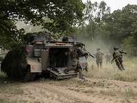 Soldaten laufen aus einem Schützenpanzer Marder ins Gelände