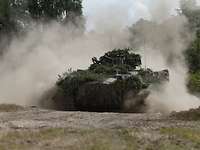 Ein Schützenpanzer Marder fährt im Gelände und wirbelt Staub auf