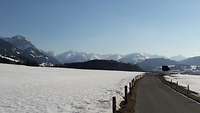 Gebirge um Altenstadt Landstrasse mit Blick auf schneebedeckte Wiesen und Berge